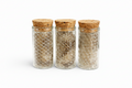 Three glass jars with cork lids on a white background with snake shed skin 